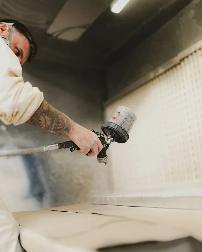 Carrossier appliquant une peinture au pistolet